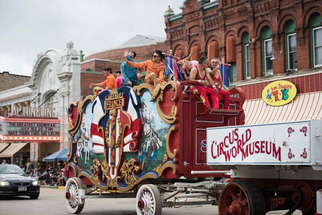 Circus performers sit atop wagon in 2019 parade